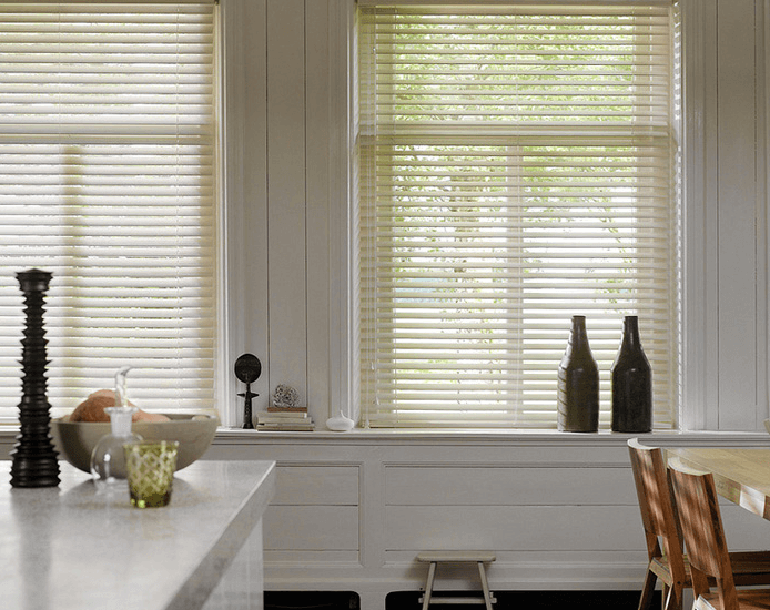 kitchen island with two white wooden blinds above it.