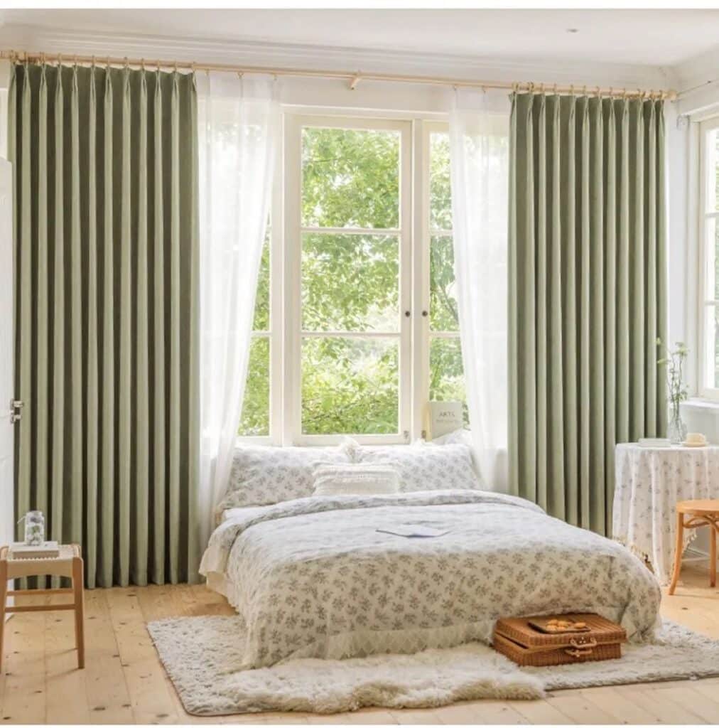 green blackout curtains in cozy bedroom half open with a view to garden