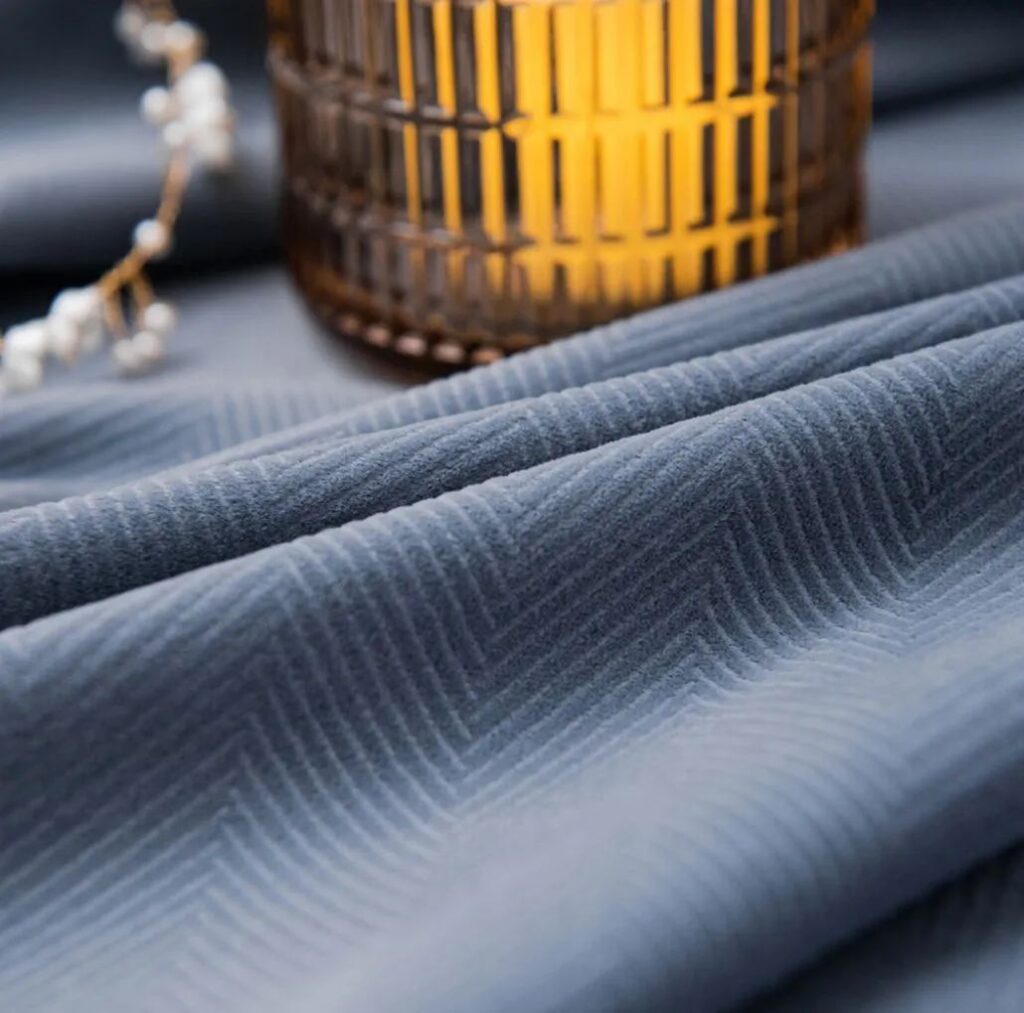 closeup view of curtain fabric velvet with lit candle placed over it