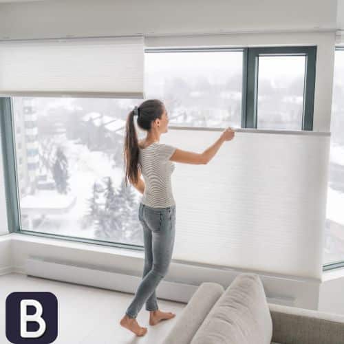 woman closing white honeycomb blind top down bottom up cordless